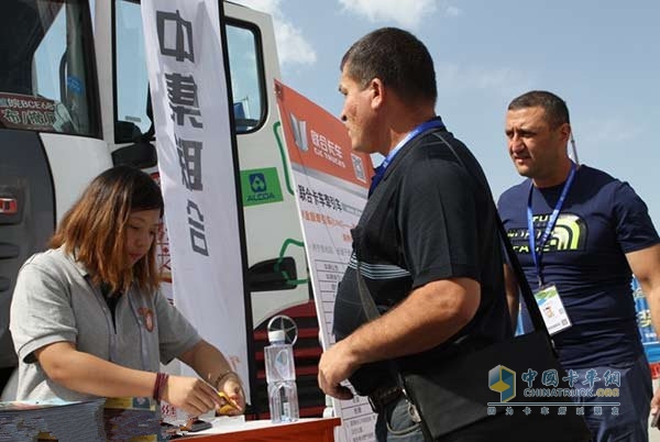 在亞歐博覽會室外嘉年華展區(qū)，聯(lián)合卡車營銷服務(wù)人員正在接待兩名俄羅斯客戶