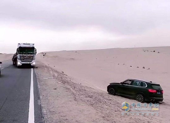 竇向永用卡車救陷入沙坑的轎車出來(lái)