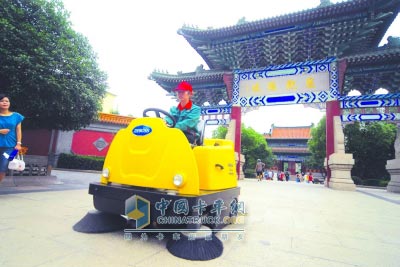 工人們正在操作新款電力清掃車對公園內(nèi)的地面進行清潔